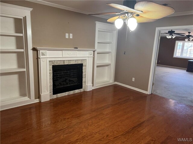 unfurnished living room featuring hardwood / wood-style floors, ornamental molding, built in features, and a tile fireplace