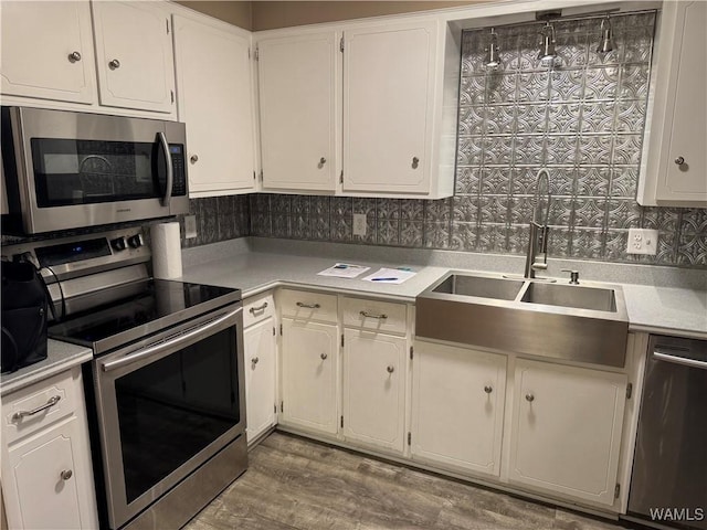 kitchen featuring white cabinetry, sink, hardwood / wood-style flooring, and stainless steel appliances