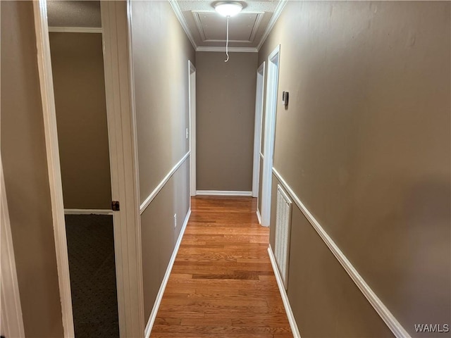 hallway featuring ornamental molding and light wood-type flooring