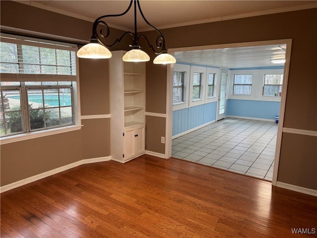 unfurnished dining area with hardwood / wood-style floors and ornamental molding