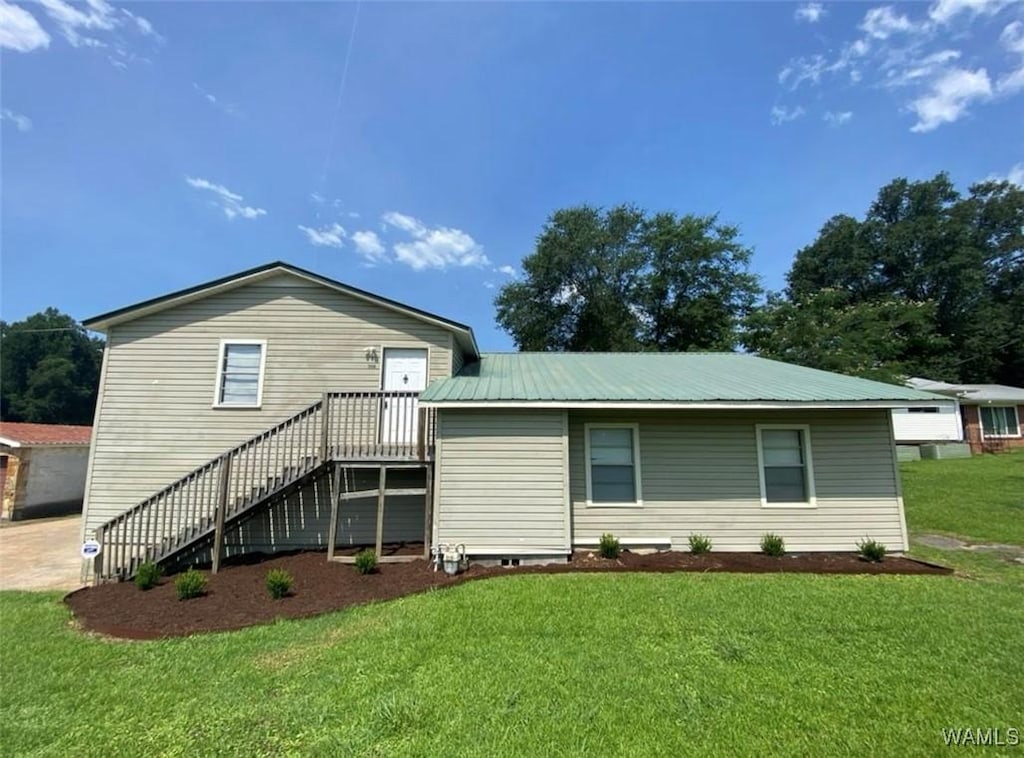 rear view of house featuring a lawn