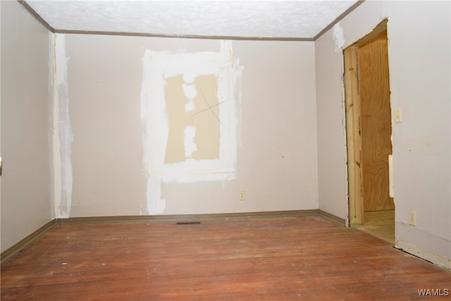 unfurnished room featuring hardwood / wood-style floors and ornamental molding