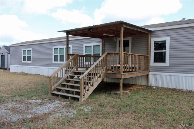 rear view of house with a deck and a lawn