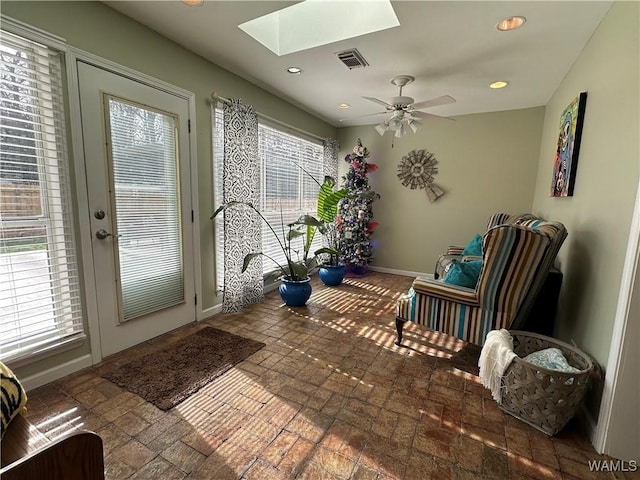 interior space with a skylight, baseboards, visible vents, and recessed lighting