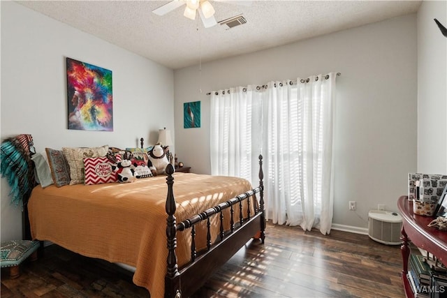 bedroom with visible vents, baseboards, dark wood-style floors, ceiling fan, and a textured ceiling