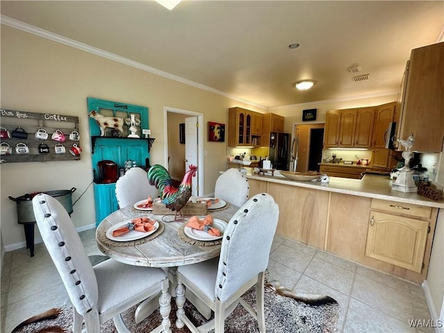 dining room featuring light tile patterned flooring, crown molding, and baseboards