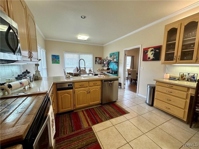 kitchen featuring stainless steel appliances, light countertops, a sink, and a peninsula