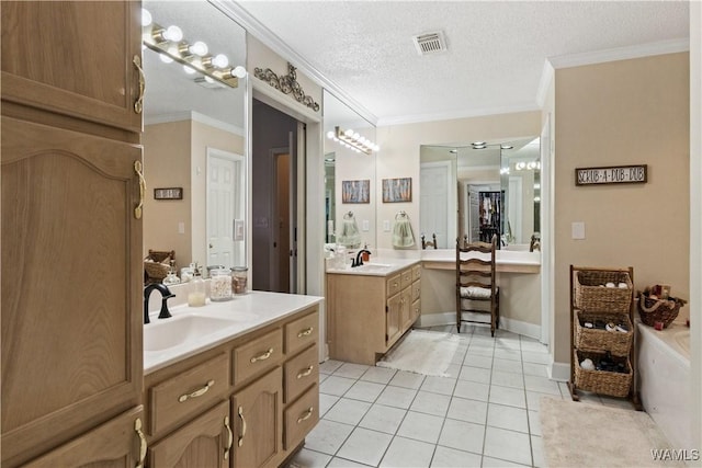 bathroom featuring a textured ceiling, visible vents, a sink, and ornamental molding