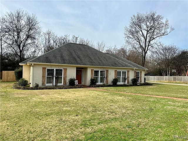 ranch-style home with brick siding, a front lawn, and fence