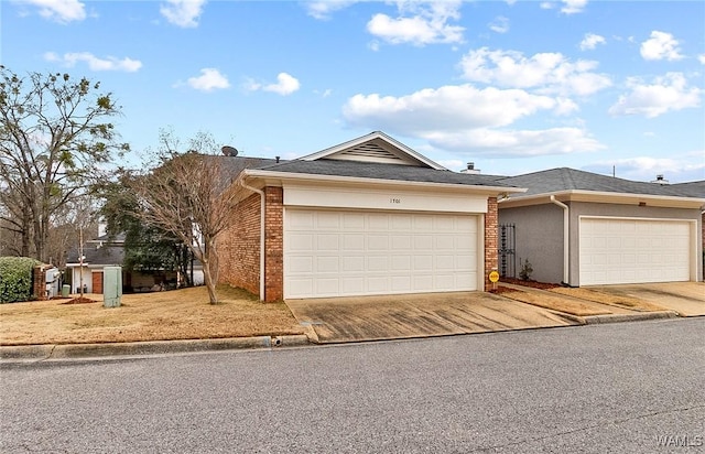 single story home featuring driveway, an attached garage, and brick siding