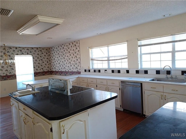 kitchen with sink, dark hardwood / wood-style floors, a textured ceiling, and dishwasher