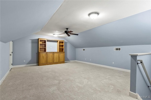 additional living space featuring ceiling fan, light colored carpet, and vaulted ceiling