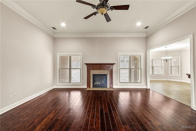 unfurnished living room with a tiled fireplace, crown molding, wood-type flooring, and ceiling fan with notable chandelier