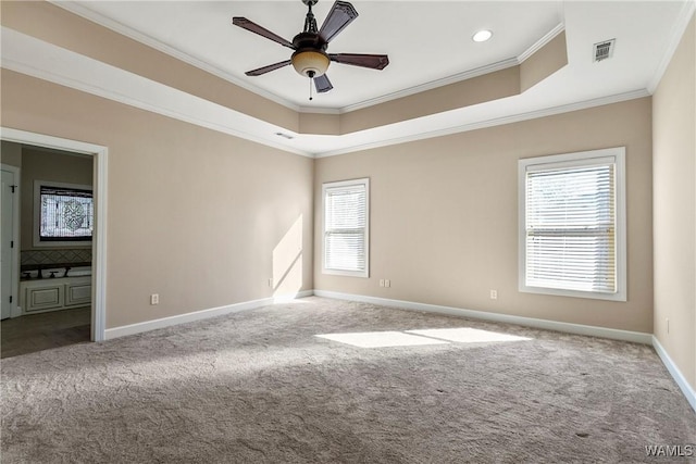 carpeted empty room with ceiling fan, ornamental molding, and a tray ceiling