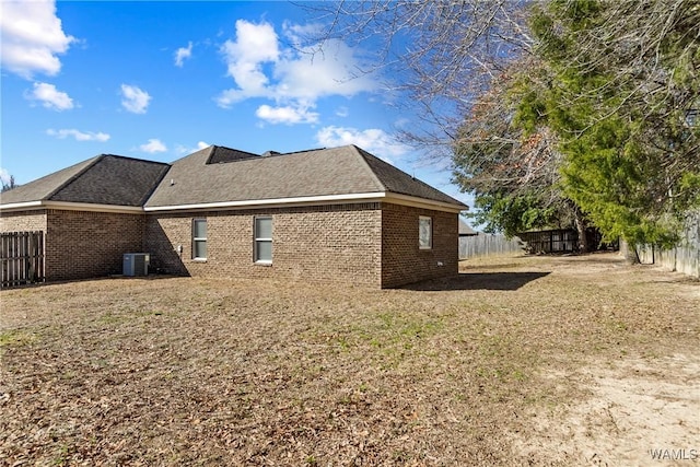 view of side of home with central AC and a lawn