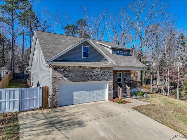 view of front of house featuring covered porch, a garage, and a front lawn