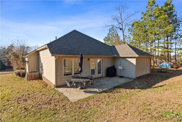 rear view of house with a yard, a patio, french doors, and roof with shingles