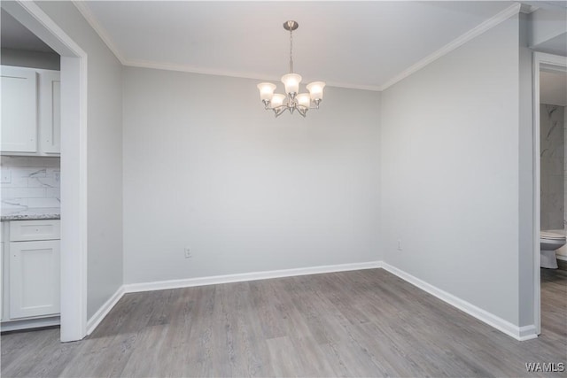 1721 Hackberry Ln Unit 6, Tuscaloosa, AL 35401 - unfurnished dining area featuring wood finished floors, a chandelier, crown molding, and baseboards