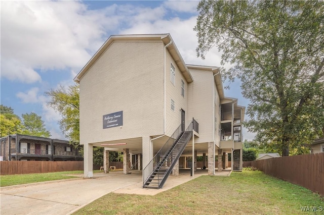 1721 Hackberry Ln Unit 6, Tuscaloosa, AL 35401 - rear view of property featuring a carport, stairway, a patio area, concrete driveway, and a sunroom