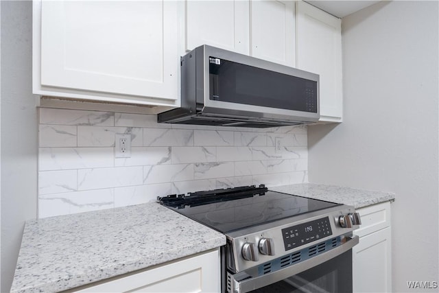 1721 Hackberry Ln Unit 6, Tuscaloosa, AL 35401 - kitchen featuring appliances with stainless steel finishes, white cabinets, decorative backsplash, and light stone countertops
