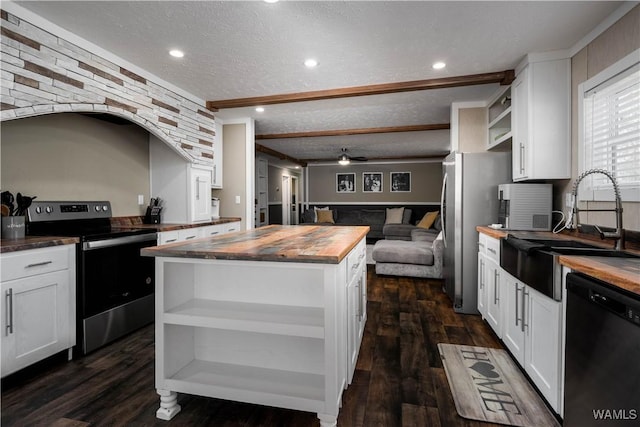 kitchen featuring wooden counters, stainless steel appliances, a textured ceiling, and open shelves