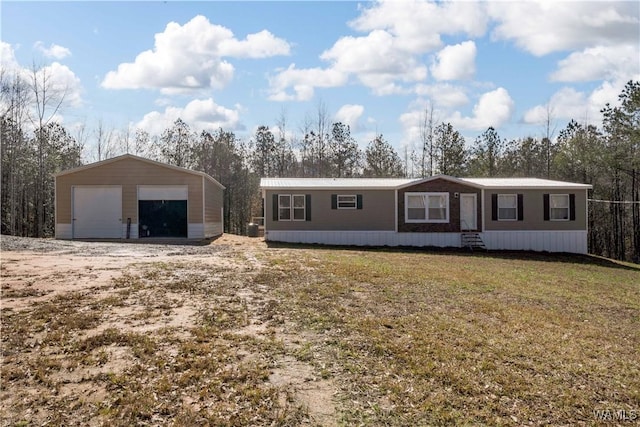 manufactured / mobile home featuring a garage, an outbuilding, and a front yard