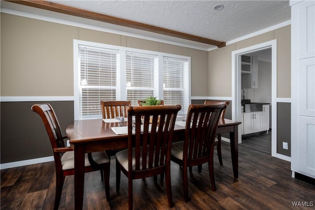 dining space with a textured ceiling, ornamental molding, and dark wood-style flooring