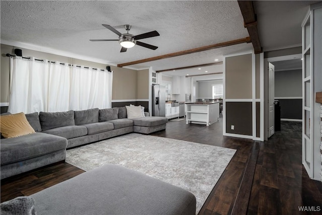 living room with a ceiling fan, dark wood-style floors, and a textured ceiling