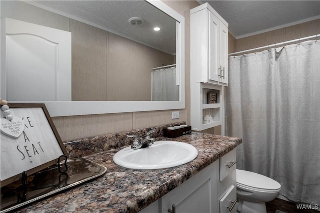 full bathroom with toilet, a textured ceiling, vanity, and ornamental molding