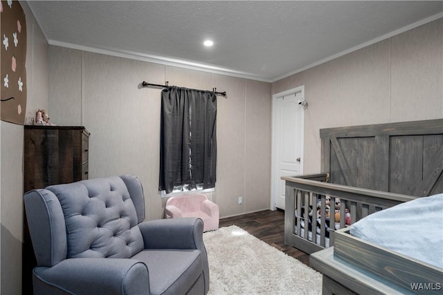 bedroom with a textured ceiling, wood finished floors, and crown molding