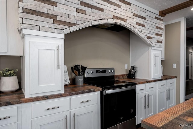 kitchen with wooden counters, white cabinetry, and stainless steel range with electric stovetop