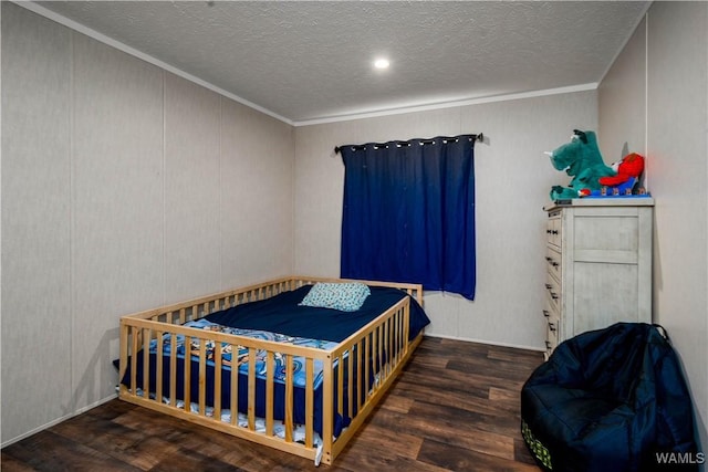 bedroom with a textured ceiling, wood finished floors, and ornamental molding