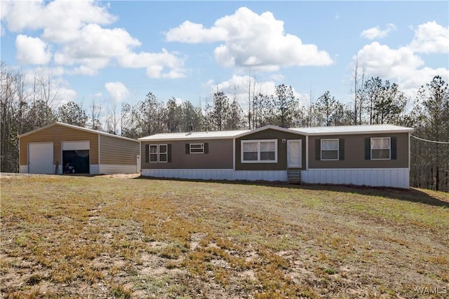 manufactured / mobile home with an outdoor structure, a garage, and a front yard