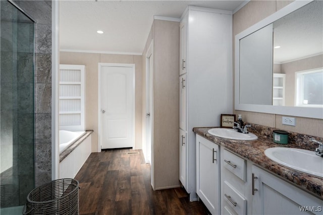 full bathroom with a sink, a stall shower, wood finished floors, and crown molding