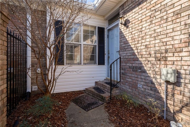 doorway to property featuring brick siding