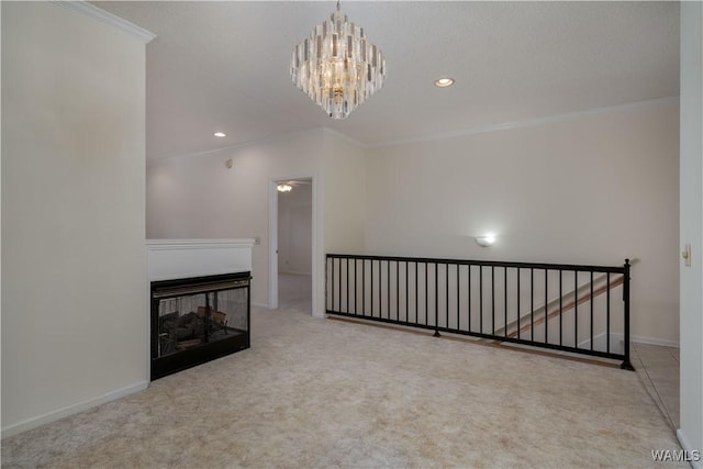 unfurnished living room featuring crown molding, baseboards, carpet, a multi sided fireplace, and a chandelier