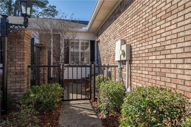 property entrance with a gate and brick siding