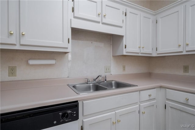 kitchen with dishwashing machine, white cabinets, light countertops, and a sink