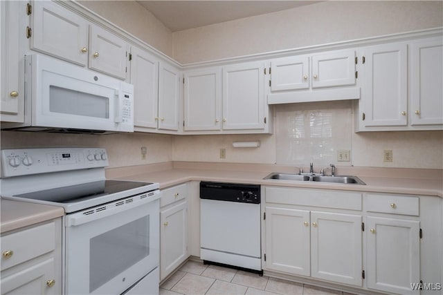 kitchen with a sink, white appliances, light countertops, and white cabinetry