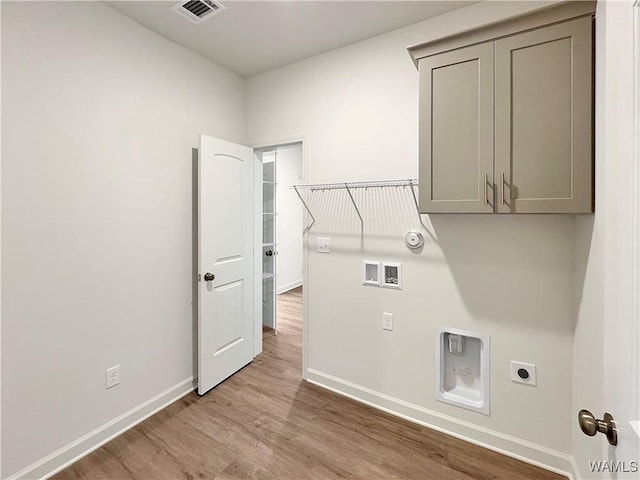 clothes washing area with cabinets, hookup for a gas dryer, washer hookup, light hardwood / wood-style floors, and electric dryer hookup