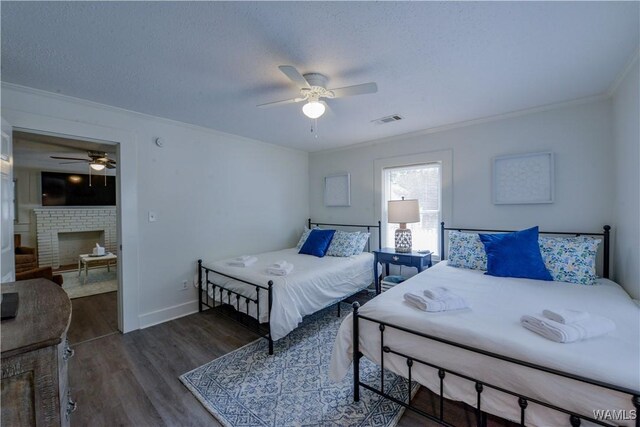3216 34th Ave, Northport, AL 35476 - bedroom with crown molding, wood finished floors, a brick fireplace, baseboards, and ceiling fan