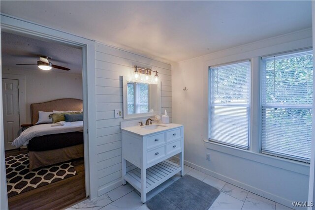 3216 34th Ave, Northport, AL 35476 - bathroom featuring marble look tile flooring, wood walls, vanity, ensuite bath, and a ceiling fan