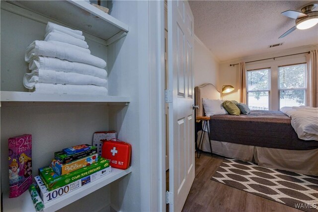 3216 34th Ave, Northport, AL 35476 - bedroom with wood finished floors, a textured ceiling, and ceiling fan