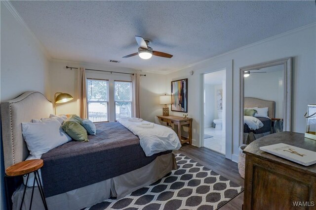 3216 34th Ave, Northport, AL 35476 - bedroom with crown molding, dark wood-type flooring, a textured ceiling, a ceiling fan, and ensuite bathroom
