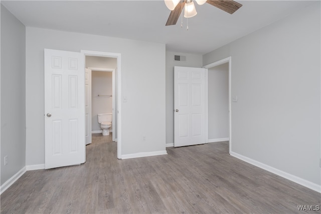 unfurnished bedroom featuring baseboards, visible vents, and wood finished floors