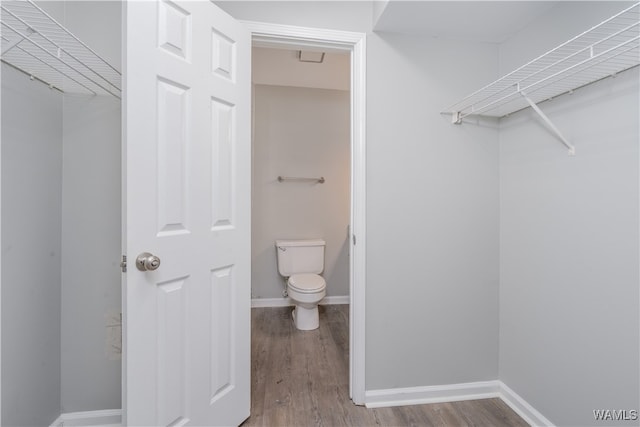 bathroom with baseboards, toilet, and wood finished floors