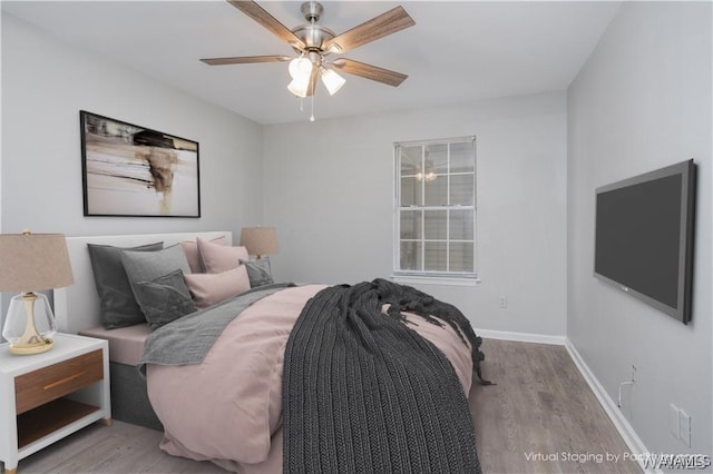 bedroom with a ceiling fan, baseboards, and wood finished floors