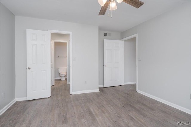 unfurnished bedroom with a ceiling fan, wood finished floors, visible vents, and baseboards