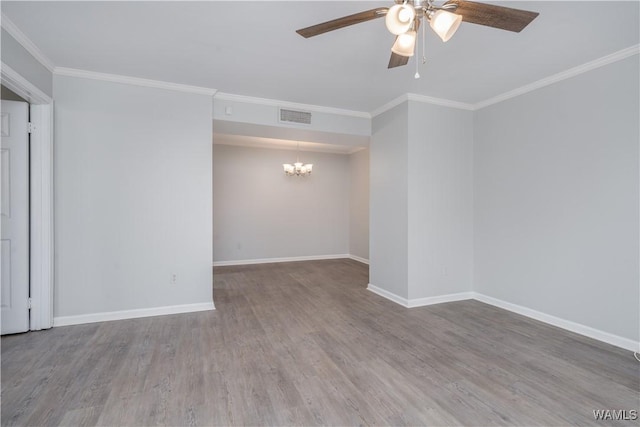 spare room featuring visible vents, ornamental molding, wood finished floors, baseboards, and ceiling fan with notable chandelier