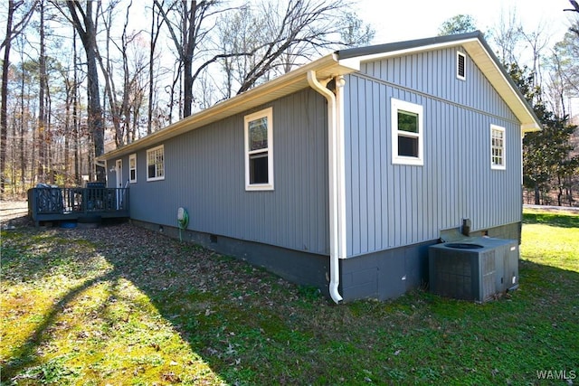 view of side of home featuring crawl space, a lawn, cooling unit, and a wooden deck